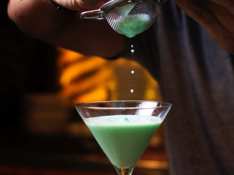straining a grasshopper cocktail